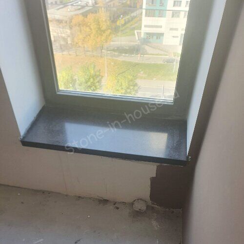 Тёмный подоконник в оконном проёме