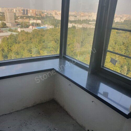Угловой тёмный подоконник у панорамного окна