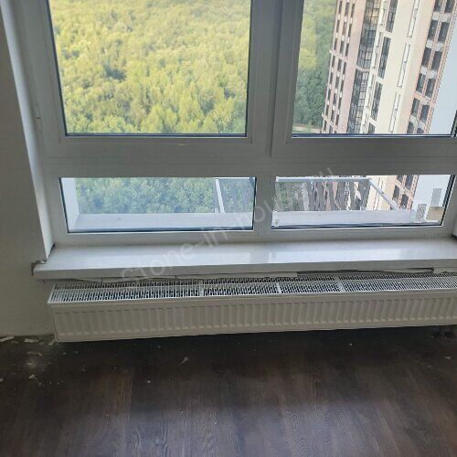 Белый подоконник у окна с видом на лес